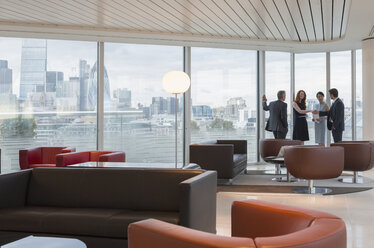 Business people meeting at windows in urban highrise lounge - CAIF06293