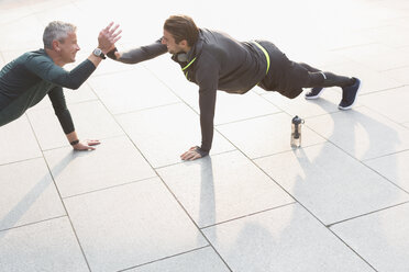 Men doing plank exercises and high-fiving - CAIF06328