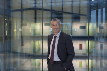 Portrait smiling, confident businessman in modern office atrium - CAIF06336