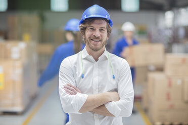 Portrait of smiling man wearing hard hat in factory - ZEF15118