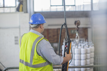 Man wearing hard hat operating control in factory - ZEF15139