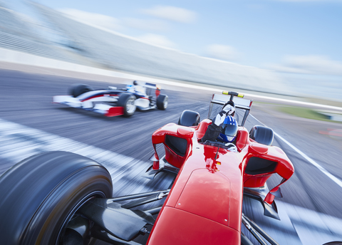 Formel-1-Rennwagen beim Überqueren der Ziellinie auf einer Sportstrecke, lizenzfreies Stockfoto