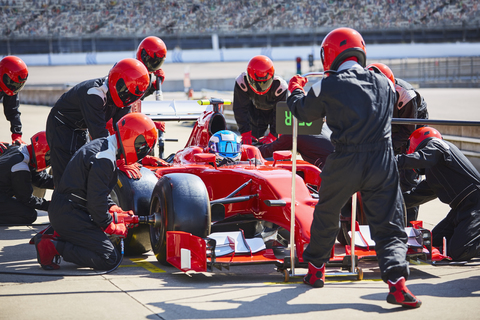 Die Boxencrew arbeitet an einem Formel-1-Rennwagen in der Boxengasse, lizenzfreies Stockfoto