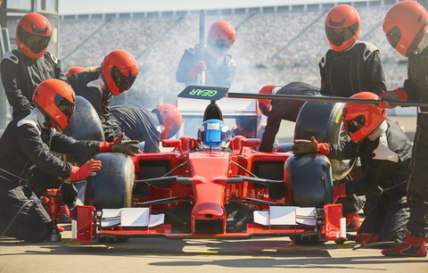 Die Boxencrew arbeitet an einem Formel-1-Rennwagen in der Boxengasse, lizenzfreies Stockfoto