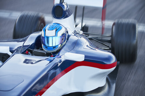 Formel-1-Rennfahrer mit Helm auf einer Sportstrecke - CAIF06413