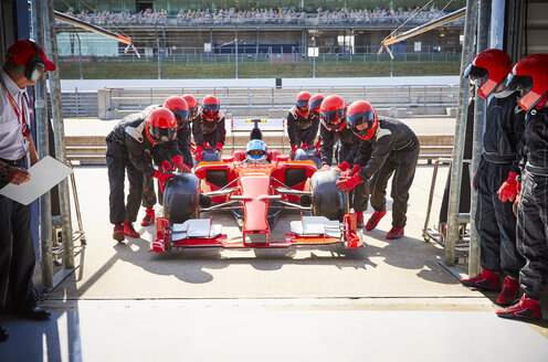 Boxencrew schiebt Formel-1-Rennwagen in die Reparaturwerkstatt - CAIF06423