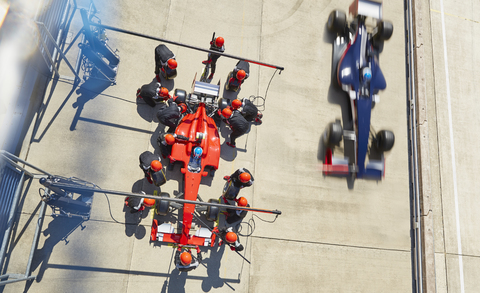 Overhead-Boxencrew beim Reifenwechsel an einem Formel-1-Rennwagen in der Boxengasse, lizenzfreies Stockfoto