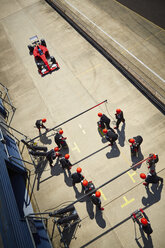 Pit crew ready for nearing formula one race car in pit lane - CAIF06456