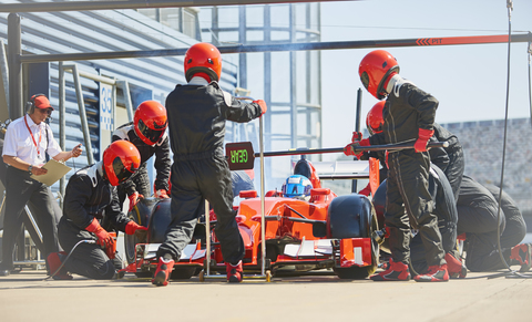 Die Boxencrew wechselt die Reifen an einem Formel-1-Rennwagen in der Boxengasse, lizenzfreies Stockfoto