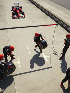 Die Boxencrew bereitet die Reifen für den sich nähernden Formel-1-Rennwagen in der Boxengasse vor - CAIF06462