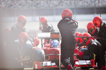 Pit crew replacing tires on formula one race car in pit lane - CAIF06506