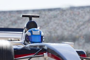Formel-1-Rennfahrer mit Helm auf der Sportstrecke - CAIF06525