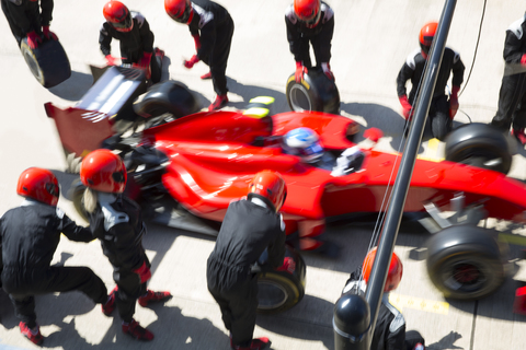 Die Boxencrew wechselt die Reifen an einem Formel-1-Rennwagen in der Boxengasse, lizenzfreies Stockfoto
