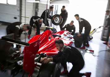 Boxenmannschaft bei der Arbeit an einem Formel-1-Rennwagen in der Reparaturwerkstatt - CAIF06535