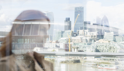 Geschäftsfrau auf städtischem Balkon mit Blick auf die Stadt, London, UK, lizenzfreies Stockfoto
