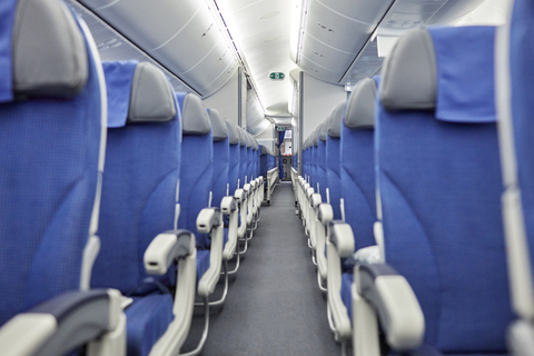 Leere blaue Sitze in einer Reihe im Flugzeug, lizenzfreies Stockfoto