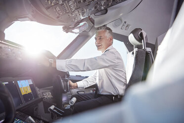 Lächelnder männlicher Pilot im Cockpit eines Flugzeugs - CAIF06586