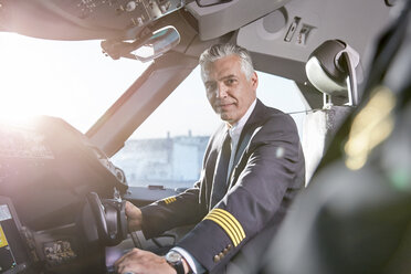 Porträt selbstbewusster männlicher Pilot im Cockpit eines Flugzeugs - CAIF06587