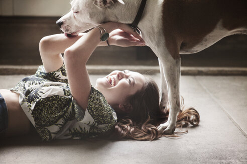 Fröhliche Frau mit Hund zu Hause - CAVF01169