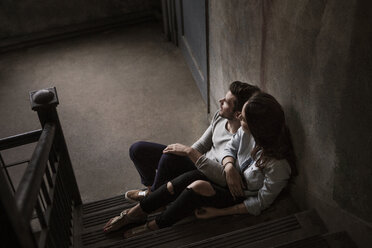 High angle view of couple sitting on stairs at home - CAVF01186