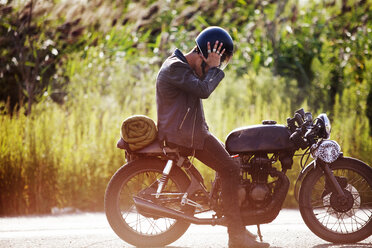 Seitenansicht eines auf einem Motorrad sitzenden Mannes - CAVF01218
