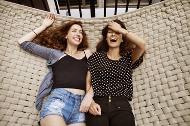 Overhead view of cheerful friends lying on hammock - CAVF01266