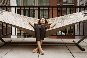 Woman sleeping on hammock in patio - CAVF01267