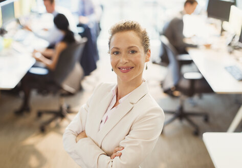 Portrait of confident businesswoman with arms crossed in office - CAIF06725