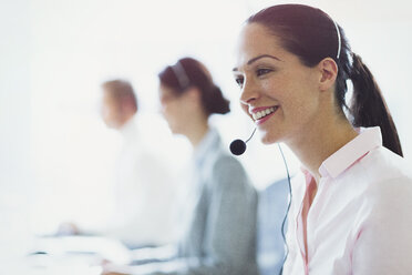 Smiling businesswoman talking on the phone with headset - CAIF06745