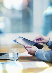 Businessman using digital tablet at conference table - CAIF06747