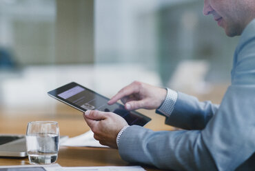 Businessman using digital tablet in office - CAIF06753