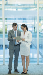 Geschäftsmann und Geschäftsfrau verwenden digitales Tablet im Büro - CAIF06773
