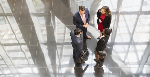 Corporate business people talking in modern office lobby - CAIF06784