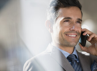 Close up smiling corporate businessman talking on cell phone - CAIF06802