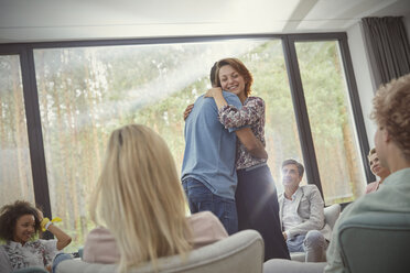 Man and woman hugging in group therapy session - CAIF06850