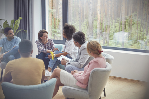 Frauen im Gespräch in einer Gruppentherapiesitzung, lizenzfreies Stockfoto