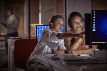 Weibliche Geschäftsfrauen arbeiten spät am Computer in einem dunklen Büro bei Nacht - CAIF06882