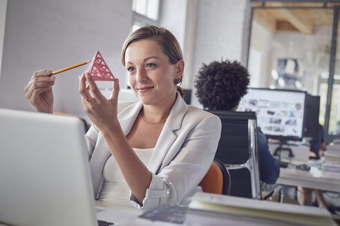 Lächelnde weibliche Design-Profi Prüfung Dreieck Prototyp am Laptop im Büro - CAIF06894
