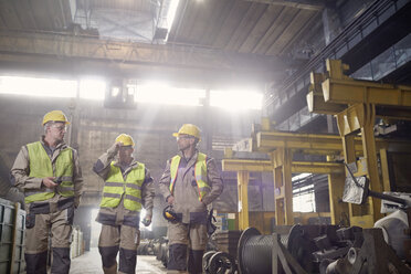 Steelworkers walking and talking in steel mill - CAIF06907