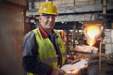 Portrait confident steelworker supervisor with clipboard in steel mill - CAIF06910