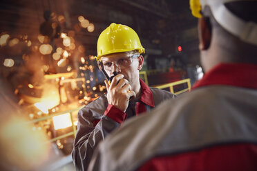 Stahlarbeiter im Gespräch mit einem Walkie-Talkie im Stahlwerk - CAIF06912