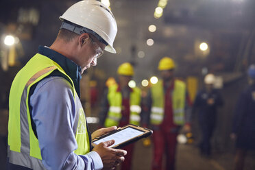 Steelworker using digital tablet in steel mill - CAIF06915