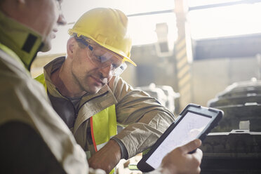 Stahlarbeiter verwenden digitales Tablet im Stahlwerk - CAIF06944