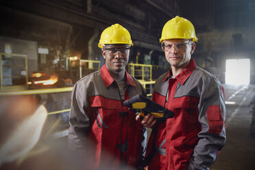 Portrait confident steelworkers with digital tablet in steel mill - CAIF06953