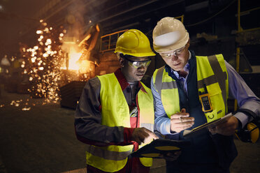 Steelworkers using digital tablets in steel mill - CAIF06954