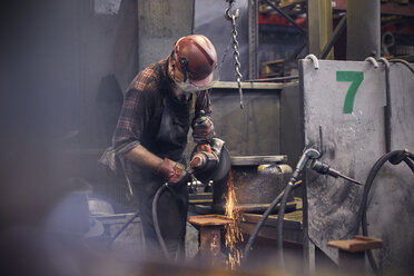 Steelworker using lathe in steel mill - CAIF06969