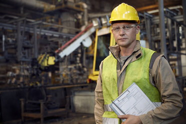 Portrait serious, confident steelworker with clipboard in steel mill - CAIF06980