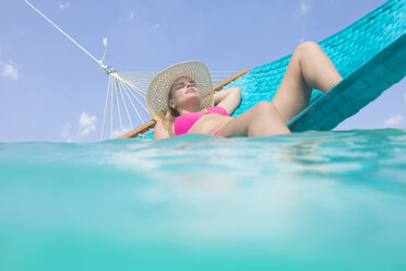 Frau entspannt sich auf einer Hängematte im Meer - ZEF15174