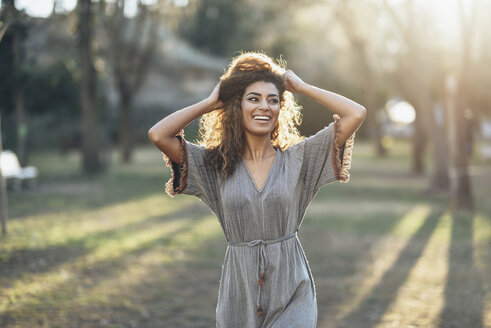 Portrait of happy young woman in a park at backlight - JSMF00092