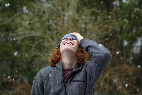 Glücklicher Teenager genießt den Schneefall, lizenzfreies Stockfoto